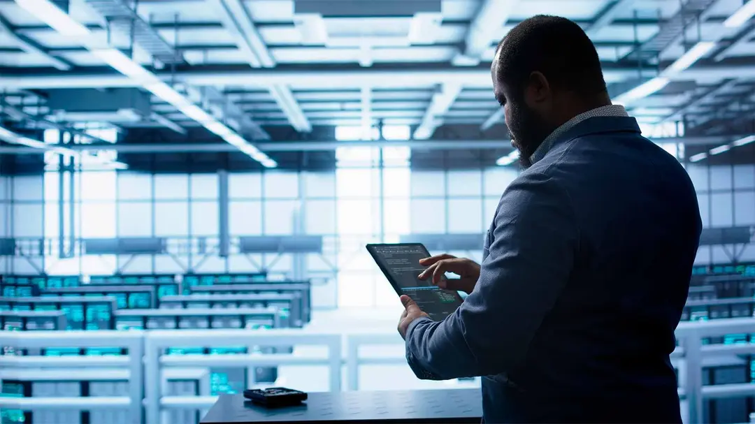 Homem em pé e de costas segundo um tablet